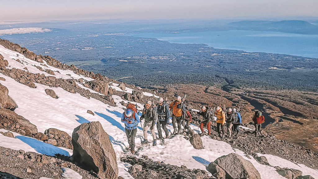 Trekking por la ladera del volcán Villarrica con el lago del mismo nombre de fondo