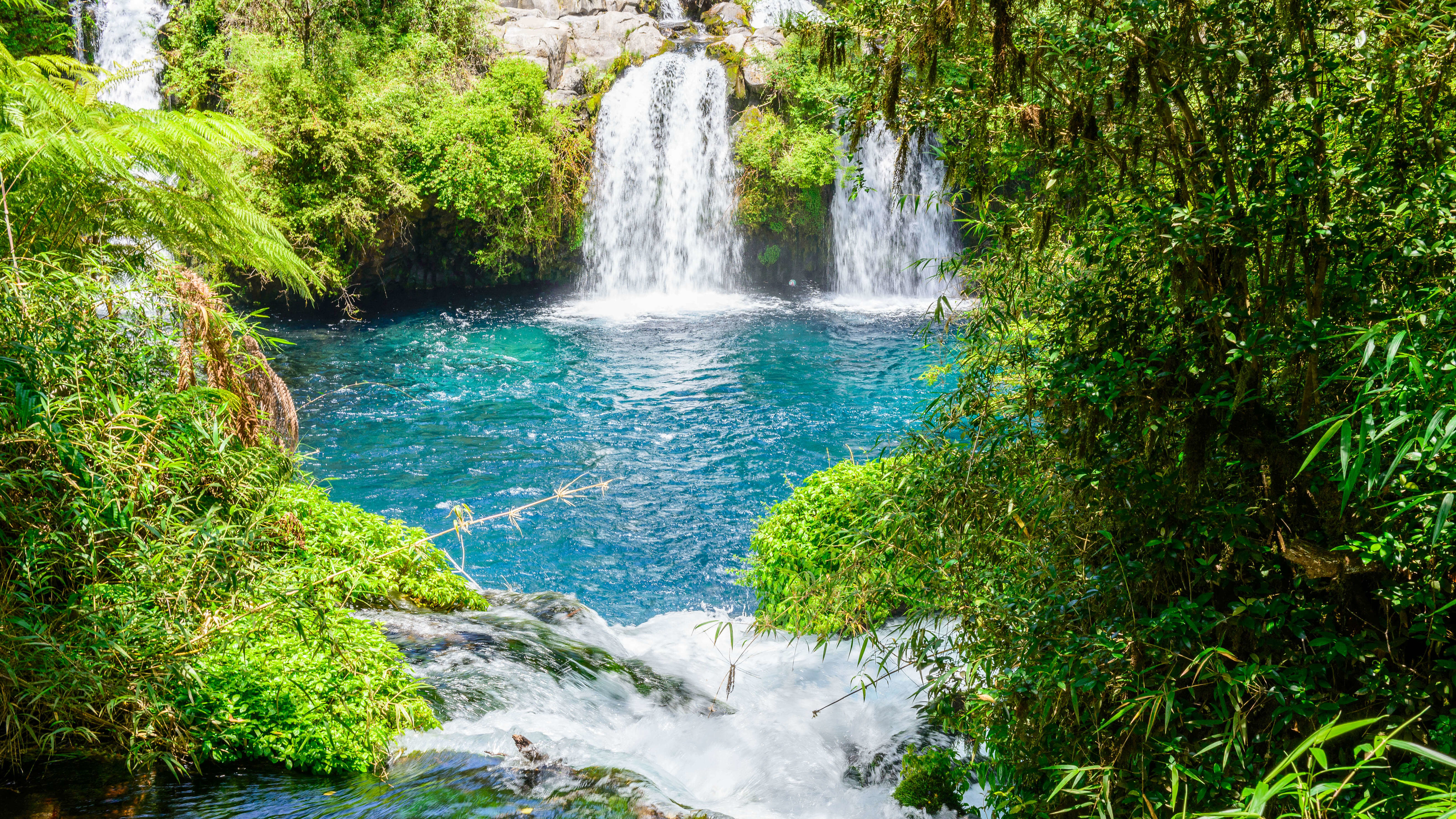 The three waterfalls of the Ojo del Caburgua are the emerald blue of the water, near Pucón.